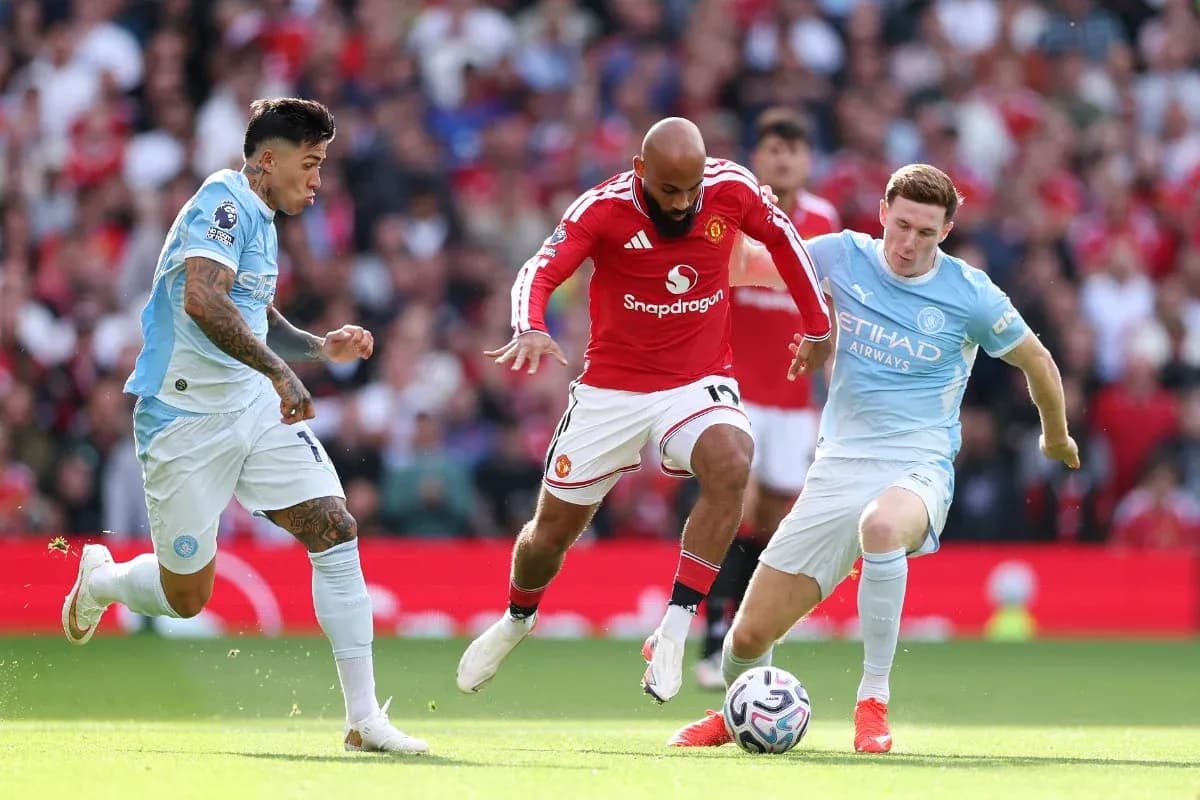 Manchester United player challenged by Manchester City opponents