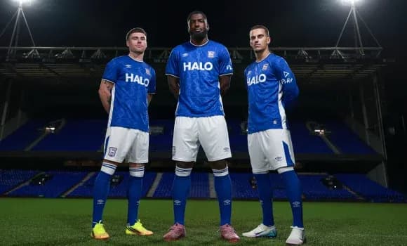 Three players posing in blue team kits