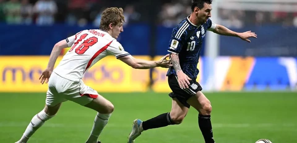 Player in blue jersey dribbling ball, opponent reaching