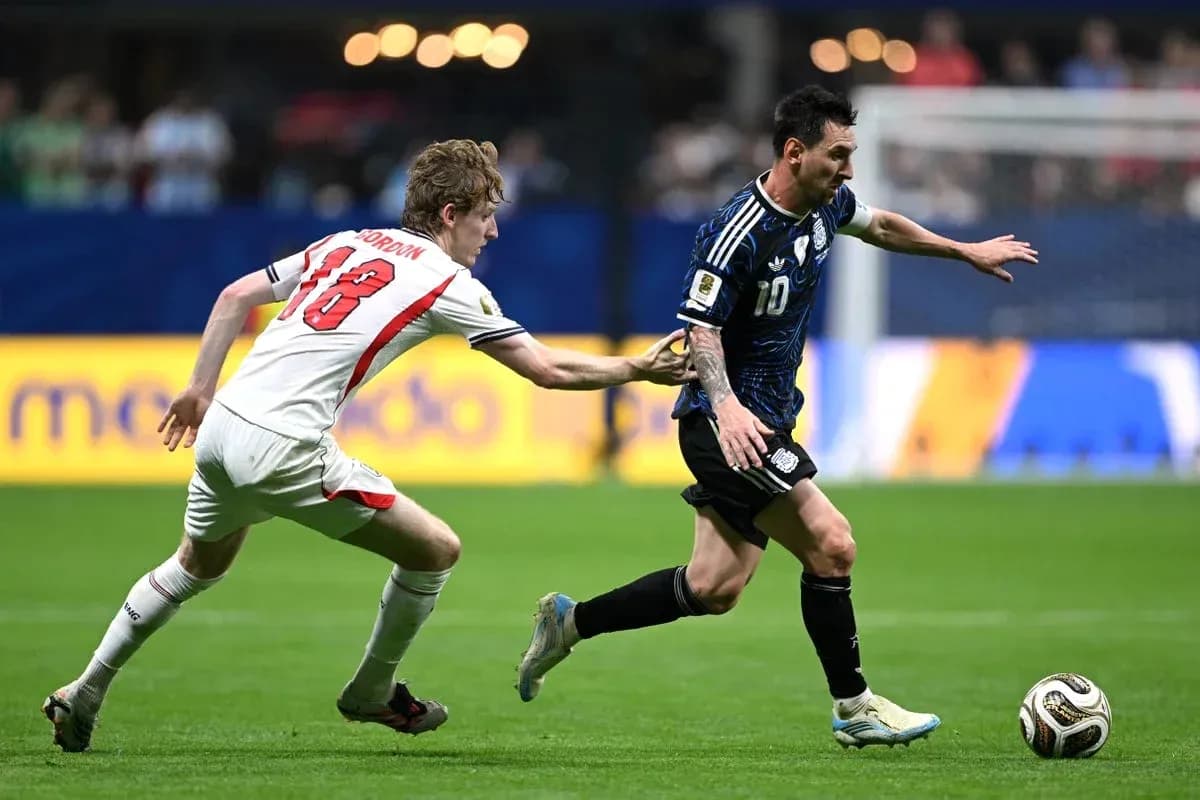 Player in blue jersey dribbling ball, opponent reaching
