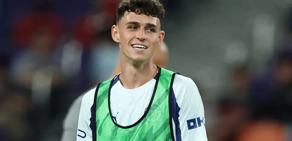 Player smiling in training bib on the pitch