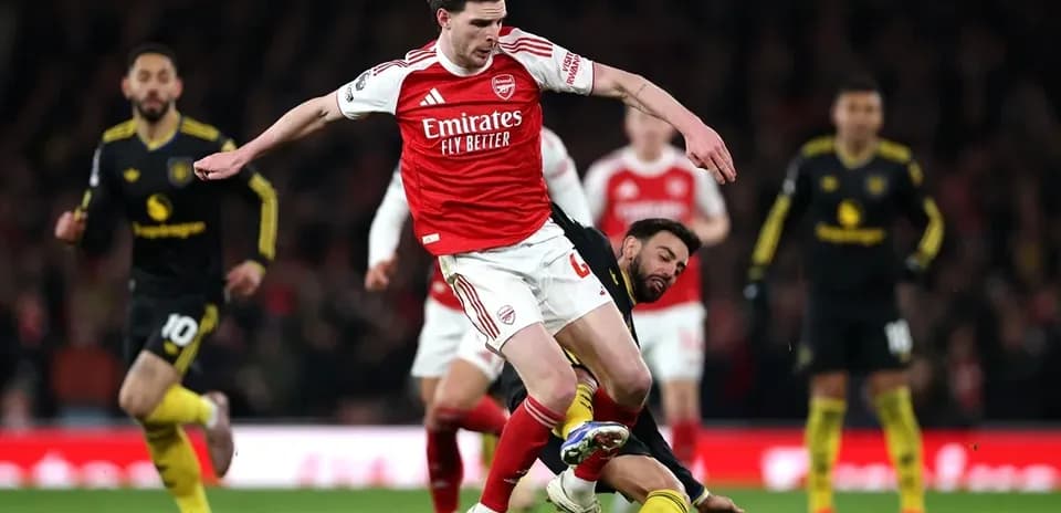Arsenal player evading opponent during match action