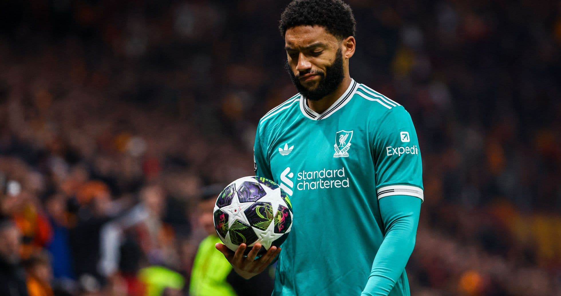 Player in teal jersey holding a soccer ball