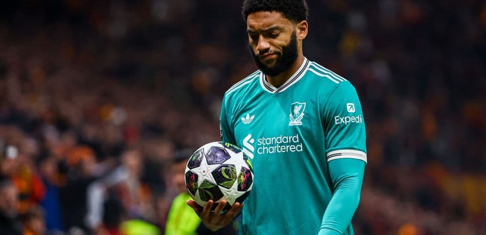 Player in teal jersey holding a soccer ball