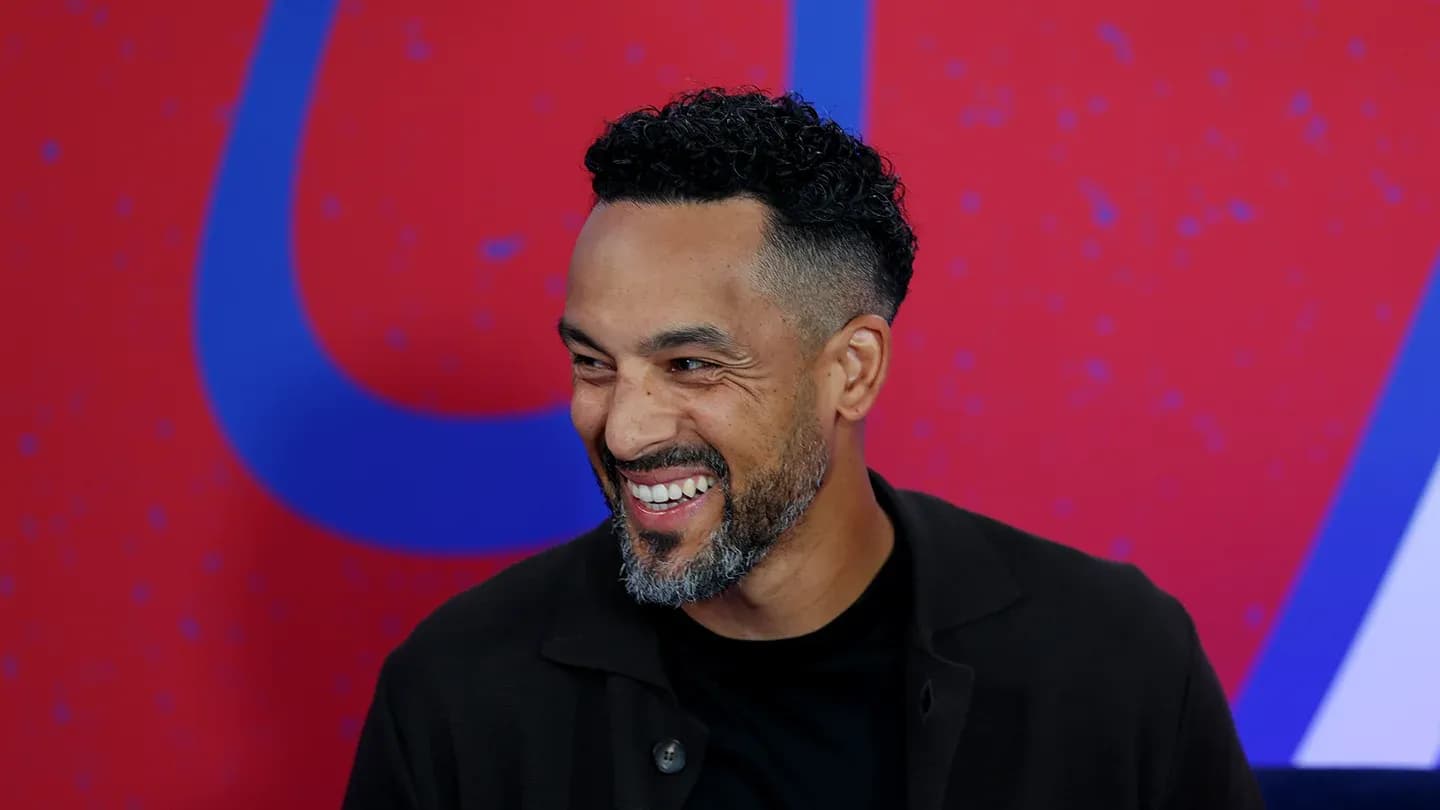 Man smiling during an event with colorful background
