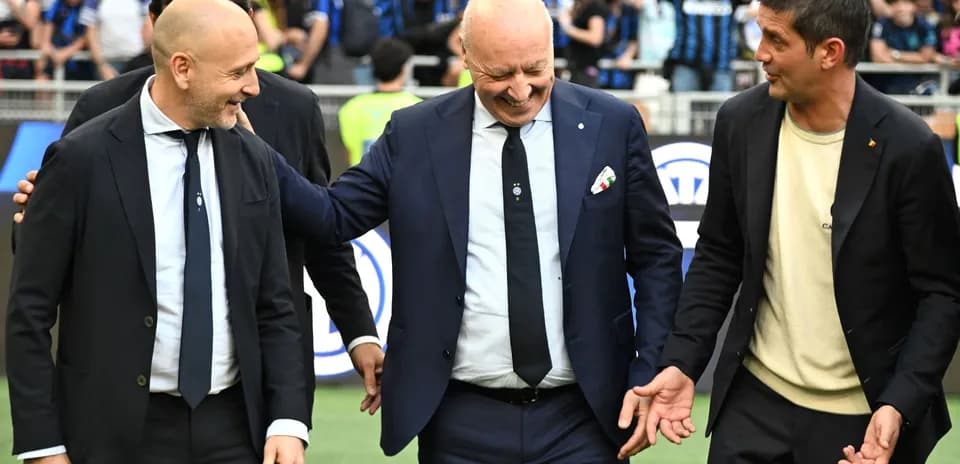 Three coaches interacting on the pitch before match