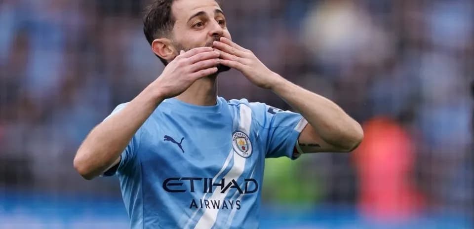 Player celebrating in Manchester City jersey on field