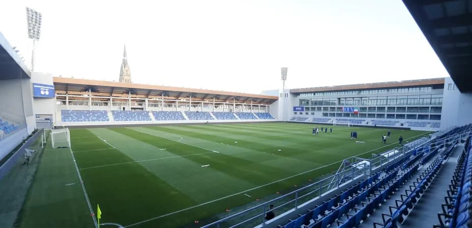Training ground with players warming up on pitch