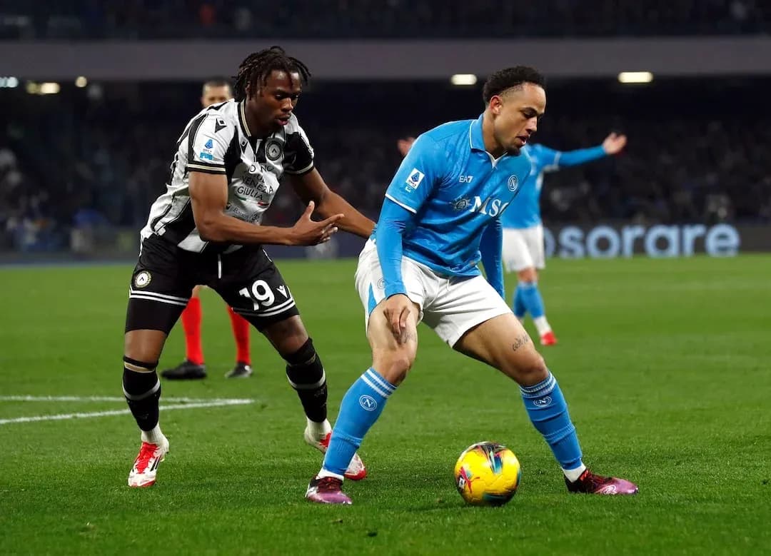 Napoli player dribbling against Udinese opponent