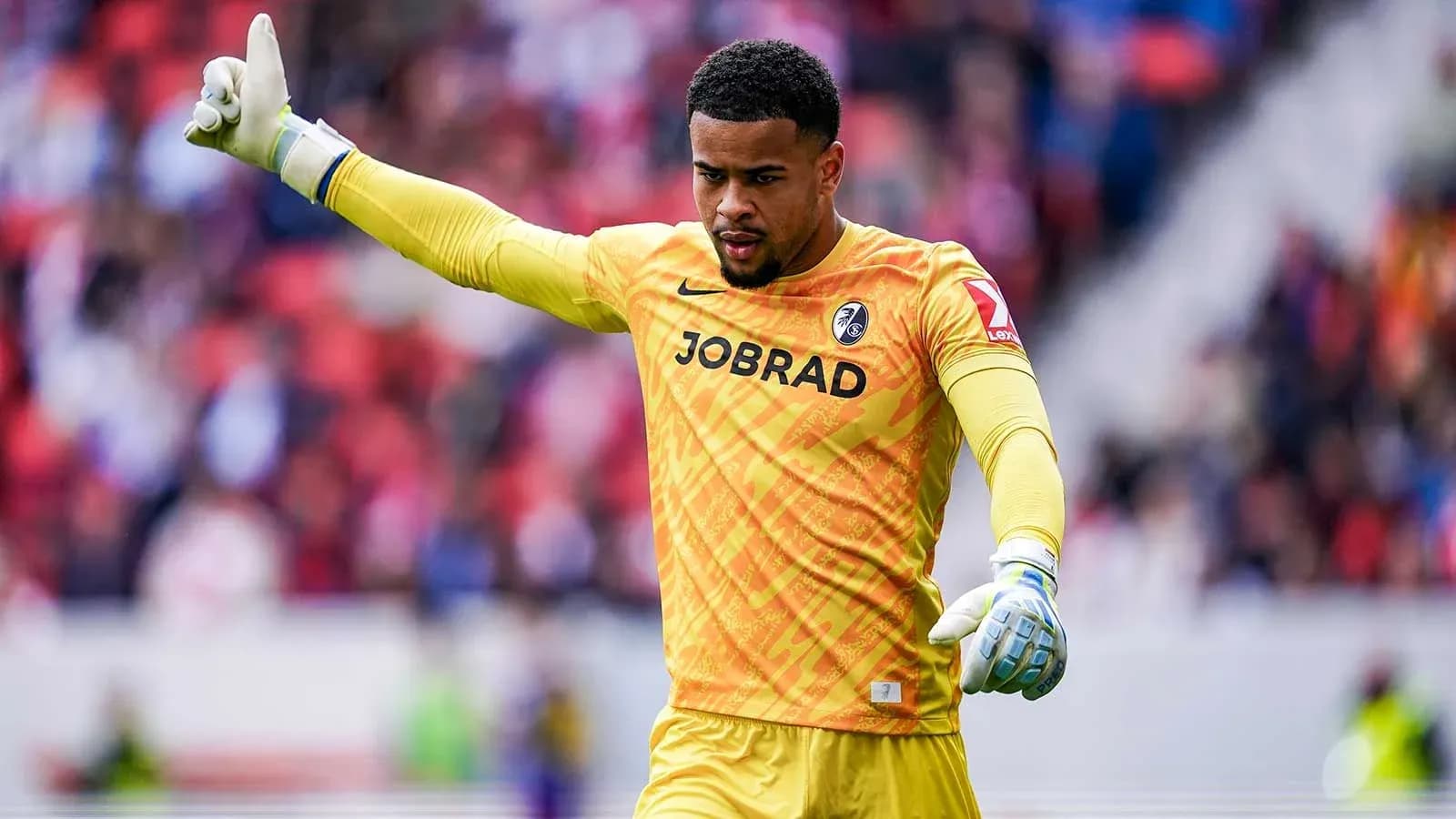 Goalkeeper gesturing during match in yellow kit