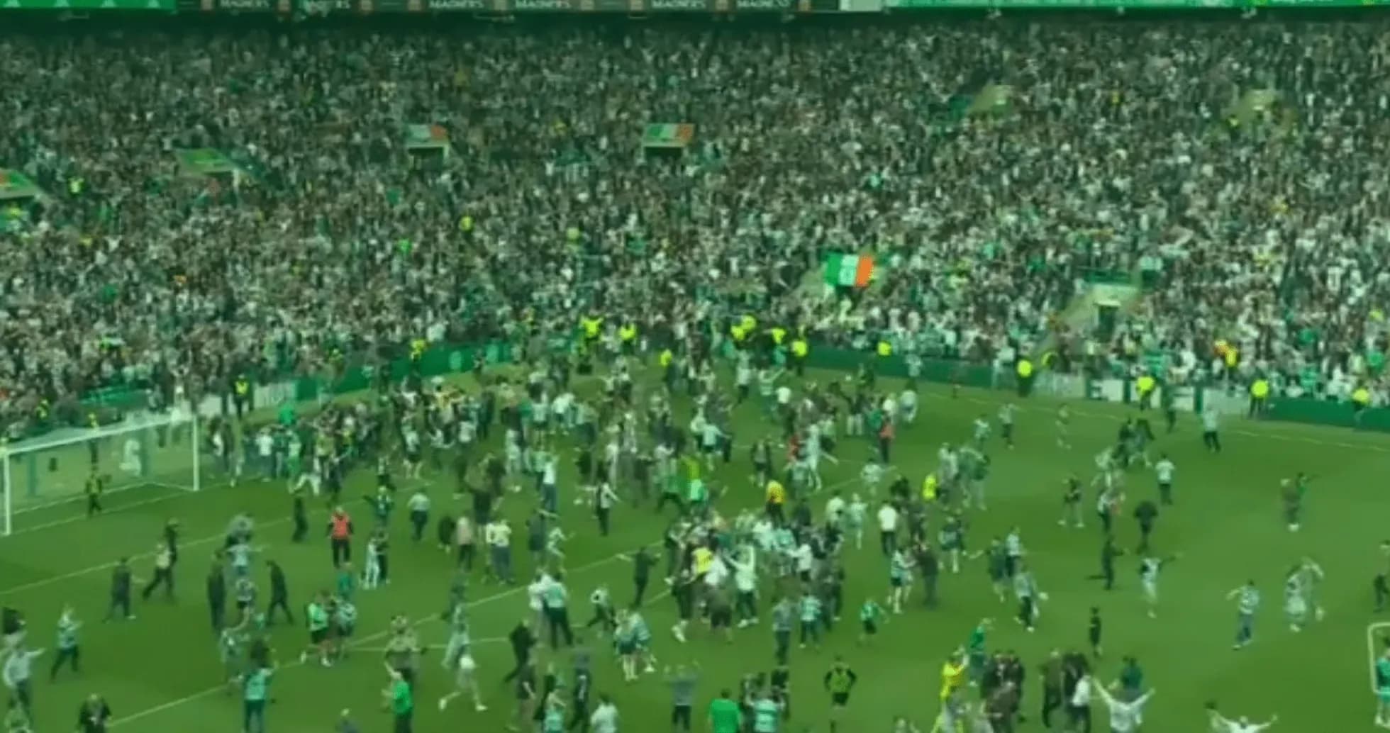 Fans celebrating on the pitch after a match