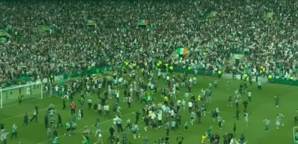 Fans celebrating on the pitch after a match