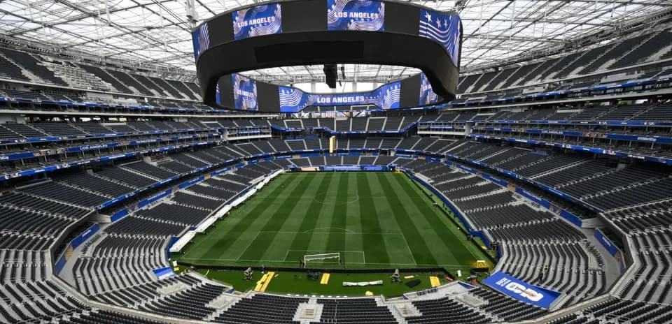 Empty stadium interior with a green soccer field