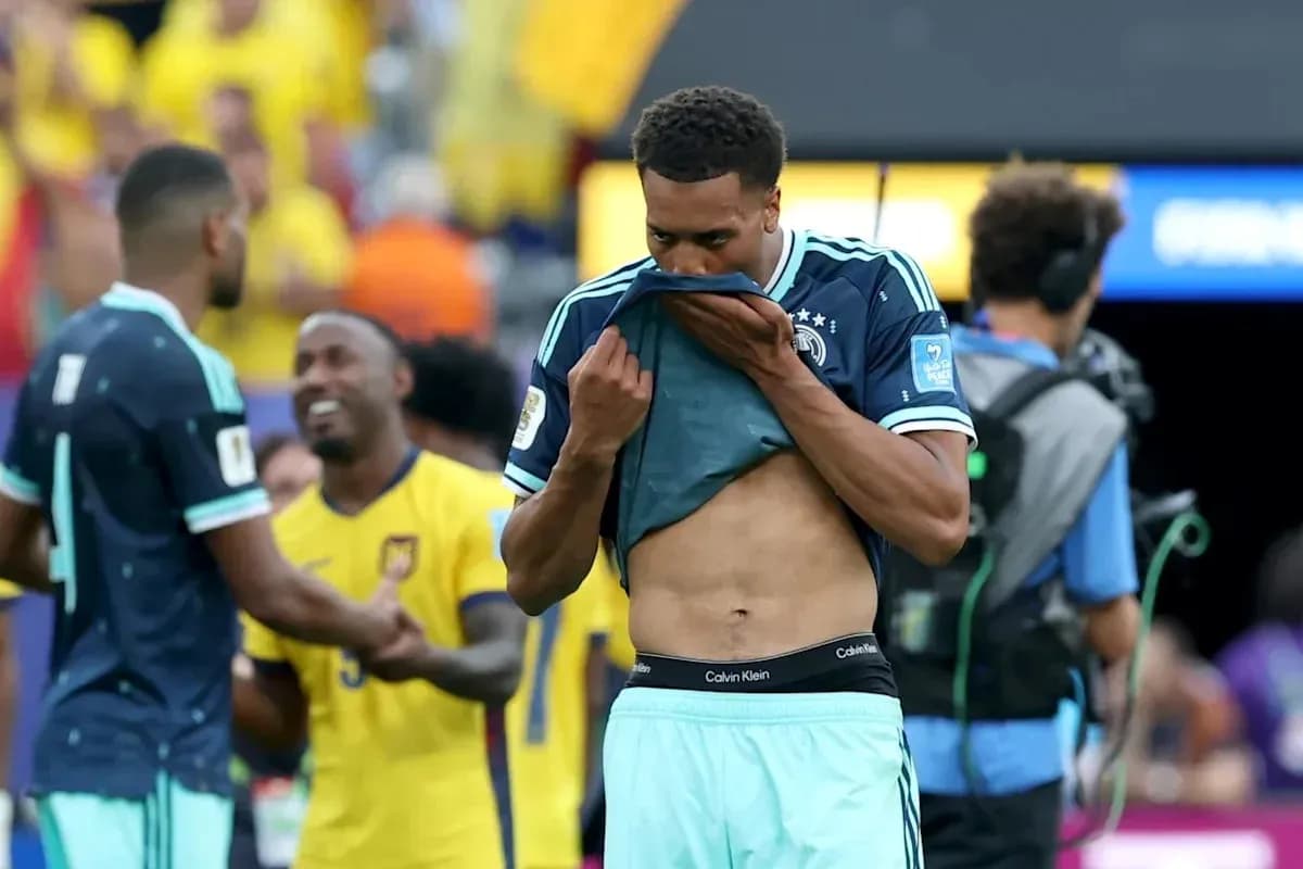 Player removing shirt after match with teammates nearby