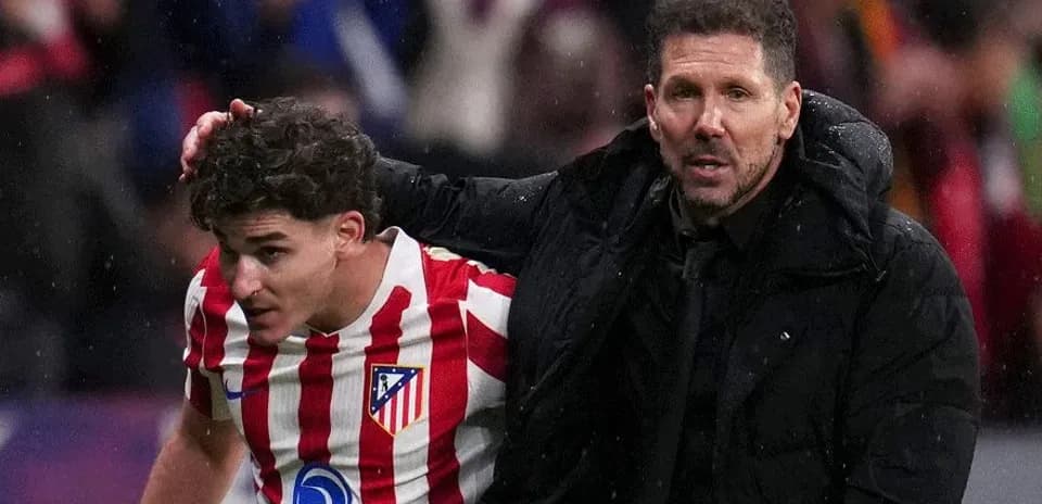 Atletico Madrid coach assisting player off the field
