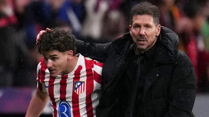 Atletico Madrid coach assisting player off the field