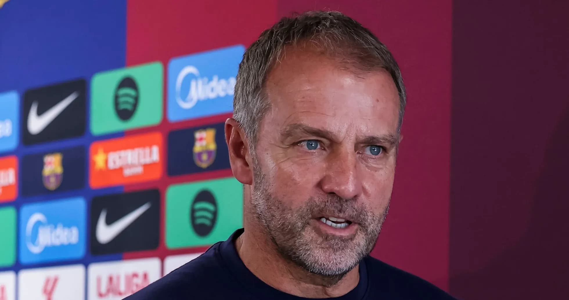 Manager speaking at press conference with logos behind