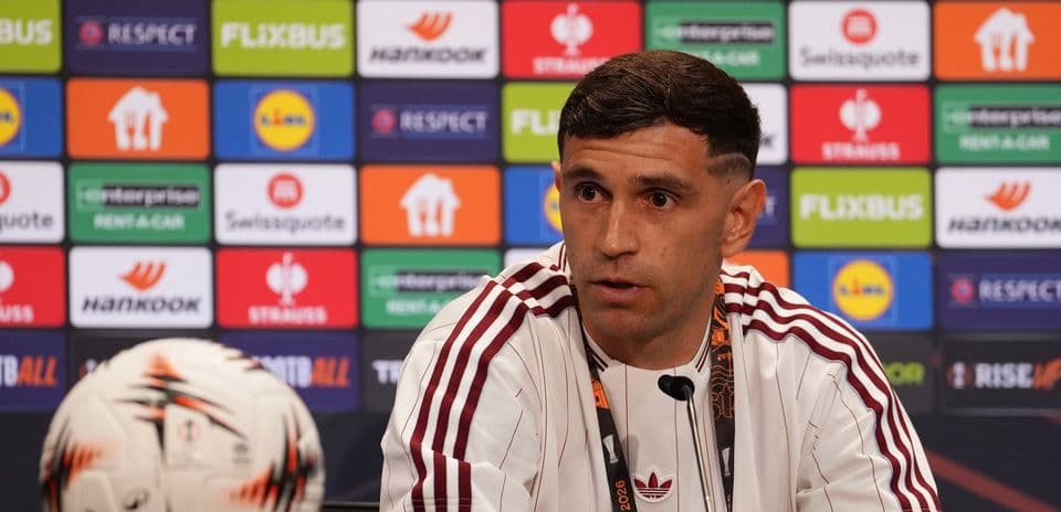 Player speaking at press conference with soccer ball