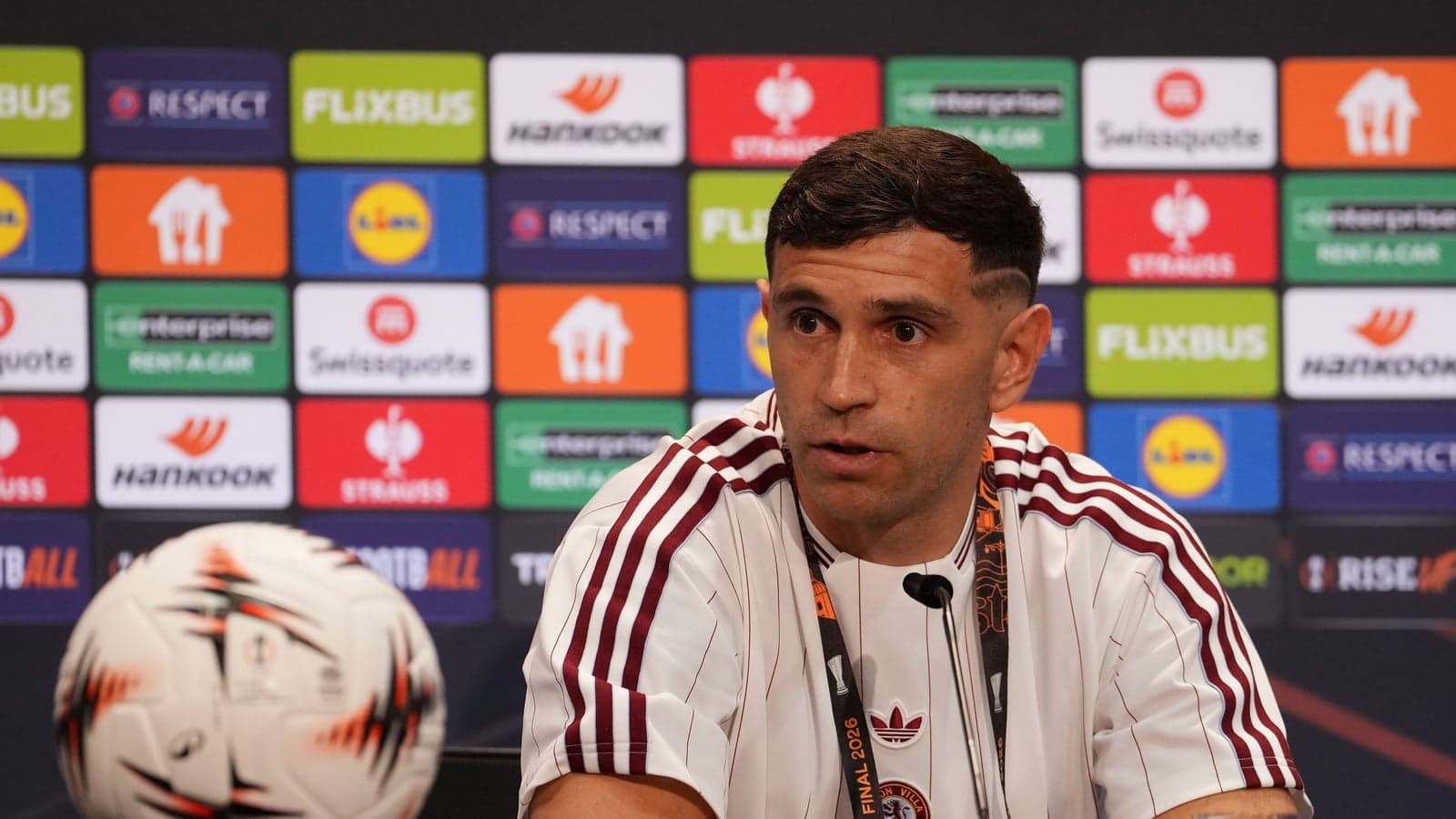 Player speaking at press conference with soccer ball