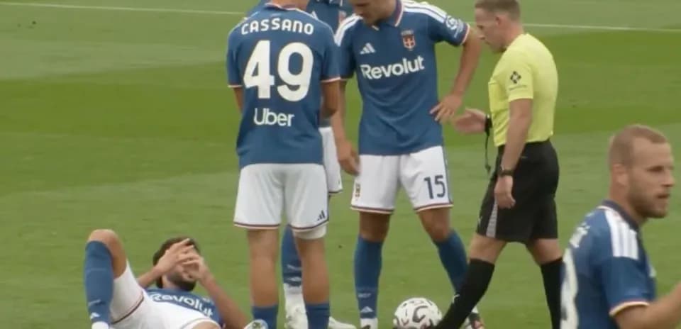 Player on the ground with teammates and referee nearby
