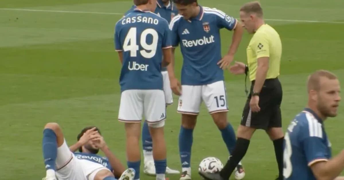 Player on the ground with teammates and referee nearby