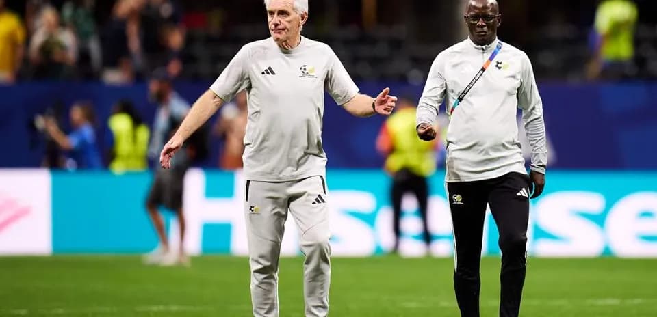 Coaches walking on the pitch during warm-up