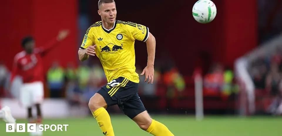 Player in yellow kit chasing a soccer ball