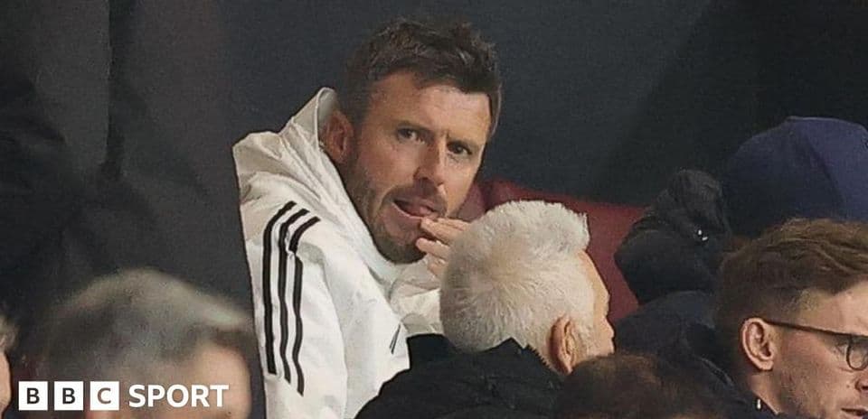 Man in white jacket seated in crowd