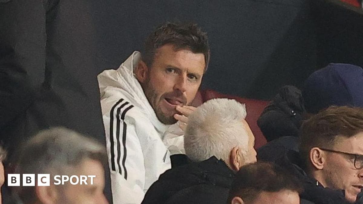 Man in white jacket seated in crowd
