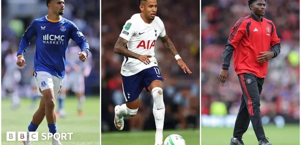 Three football players in team kits on pitch