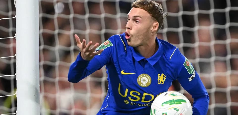 Goalkeeper in blue jersey gesturing with ball