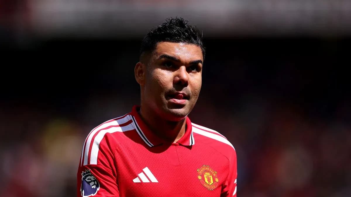Player in Manchester United jersey walking on pitch