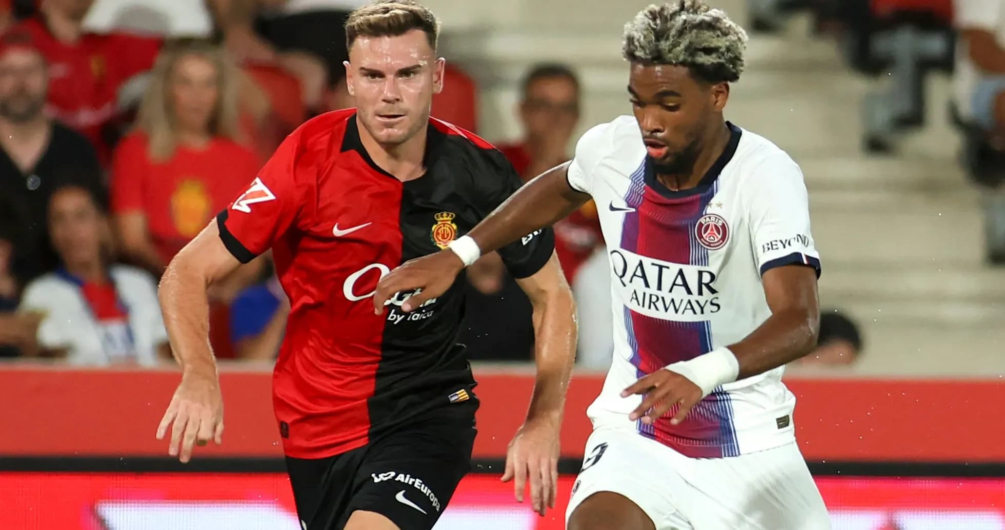 Player from PSG dribbling past Mallorca defender