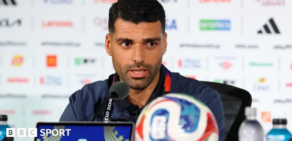 Football player speaking at press conference with ball