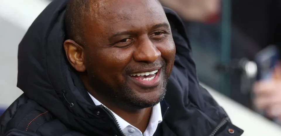 Man smiling while seated in a sports venue