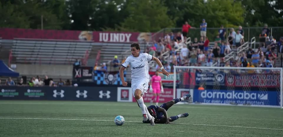 Player evading tackle during Rhode Island match