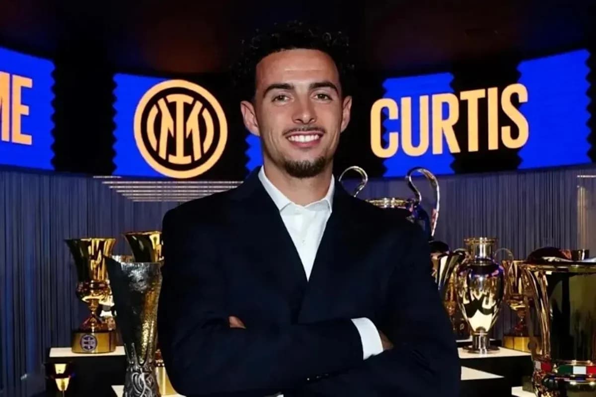 Man posing with trophies at event backdrop