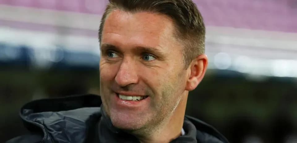 Coach smiling on the sidelines before a match