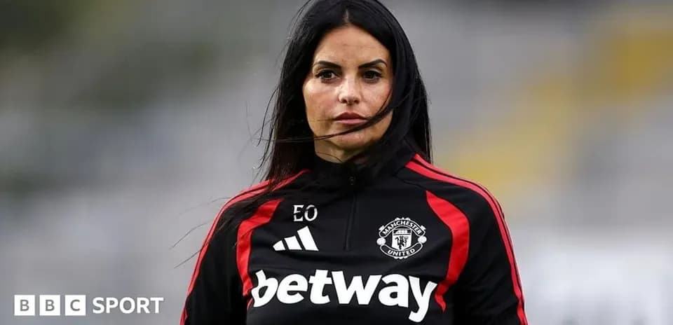 Woman in Manchester United training kit on field