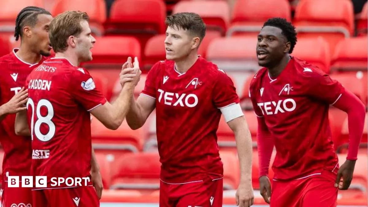 Players celebrating a goal in red team jerseys