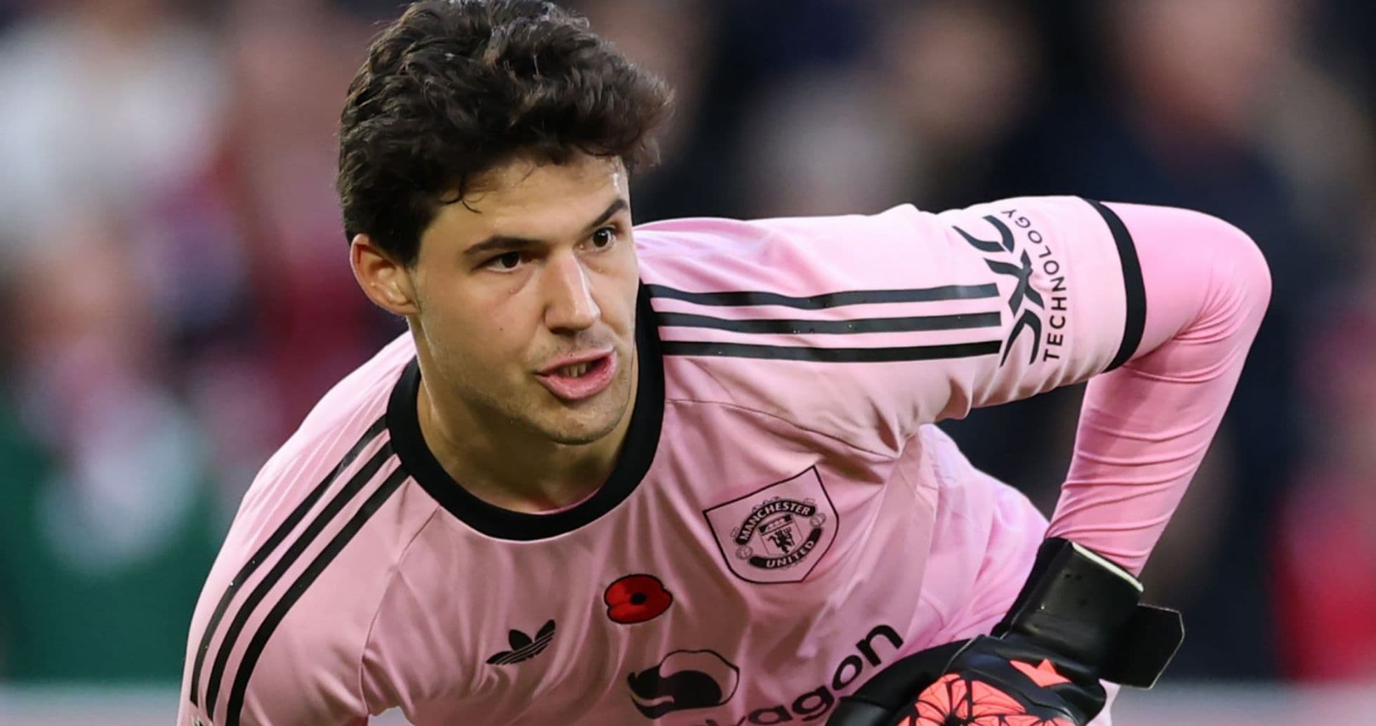 Goalkeeper in pink kit preparing for play