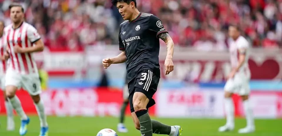 Player in black kit preparing to kick soccer ball