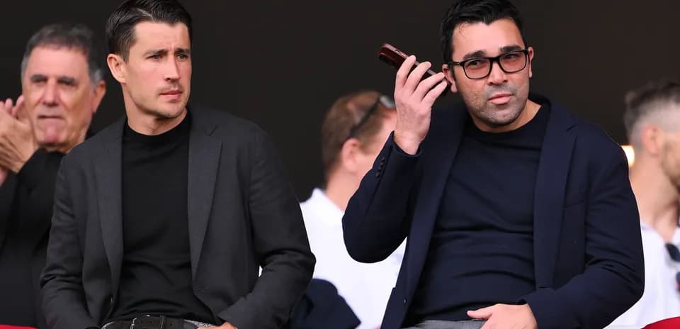 Two men sitting in stands during an event
