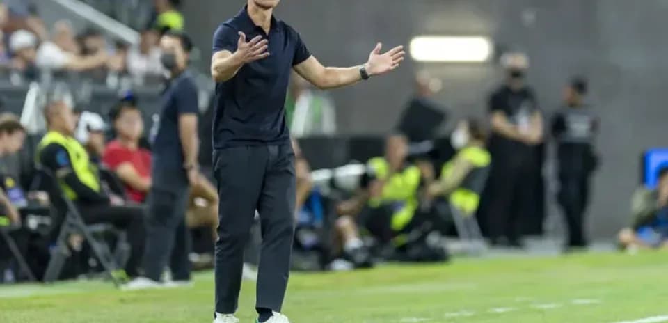 Coach gesturing during a soccer match on the sideline