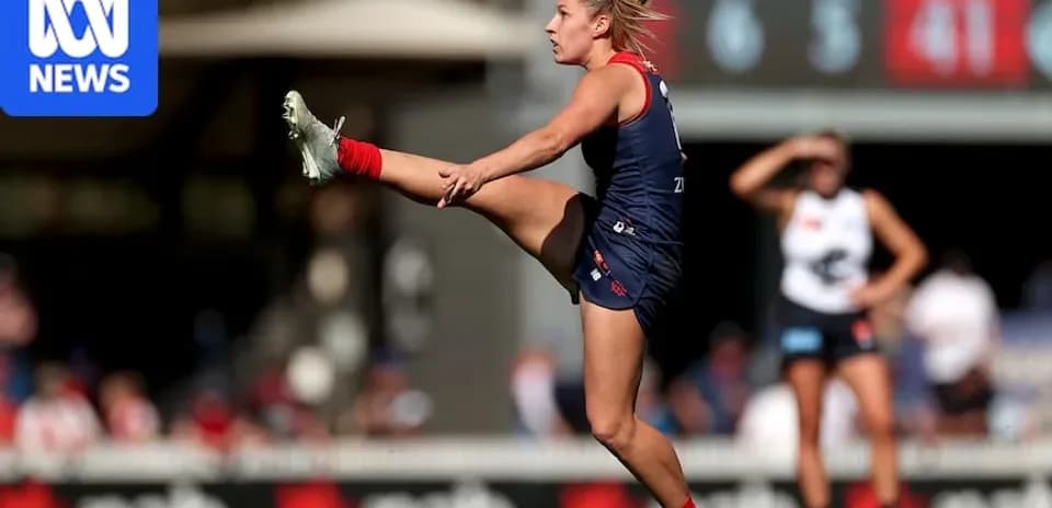 Player kicking ball during Australian rules football match