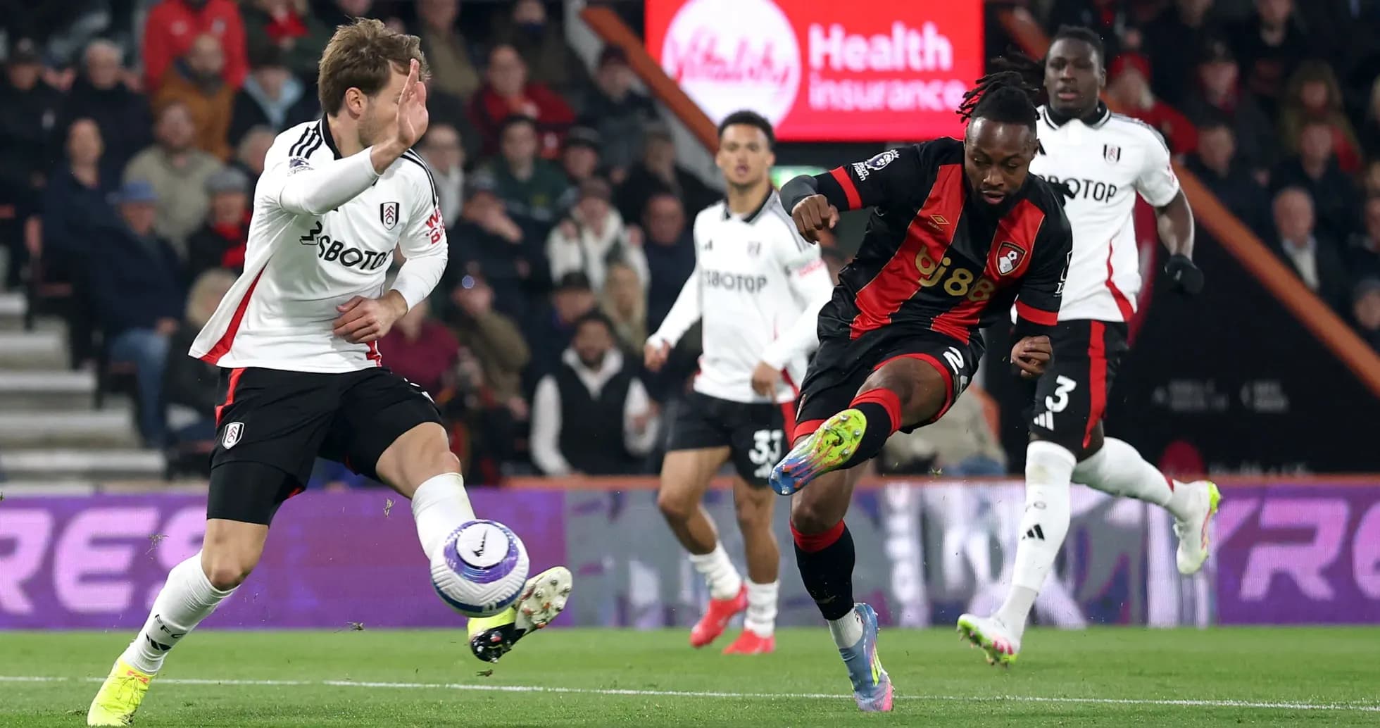 Fulham player attempting to tackle Bournemouth player