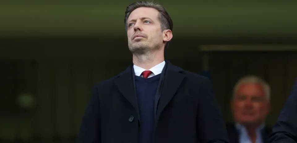 Man in formal attire observing from the stands