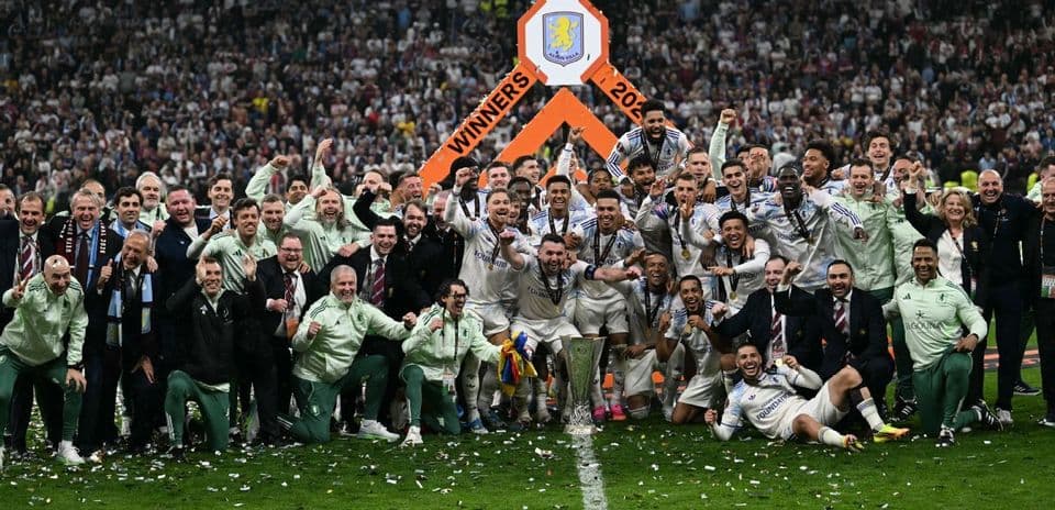 Aston Villa celebrating victory with trophy on field