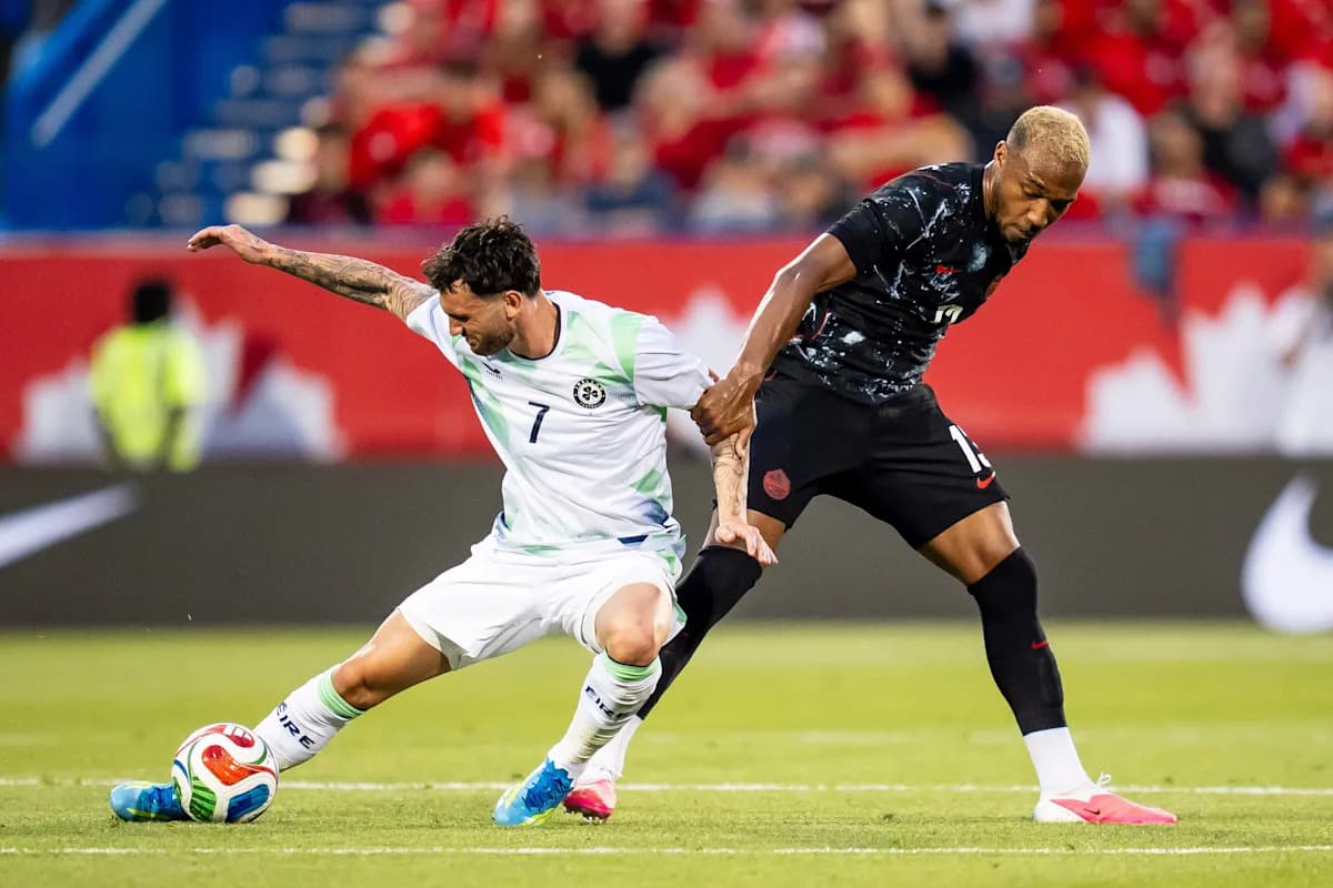 Two soccer players battling for the ball