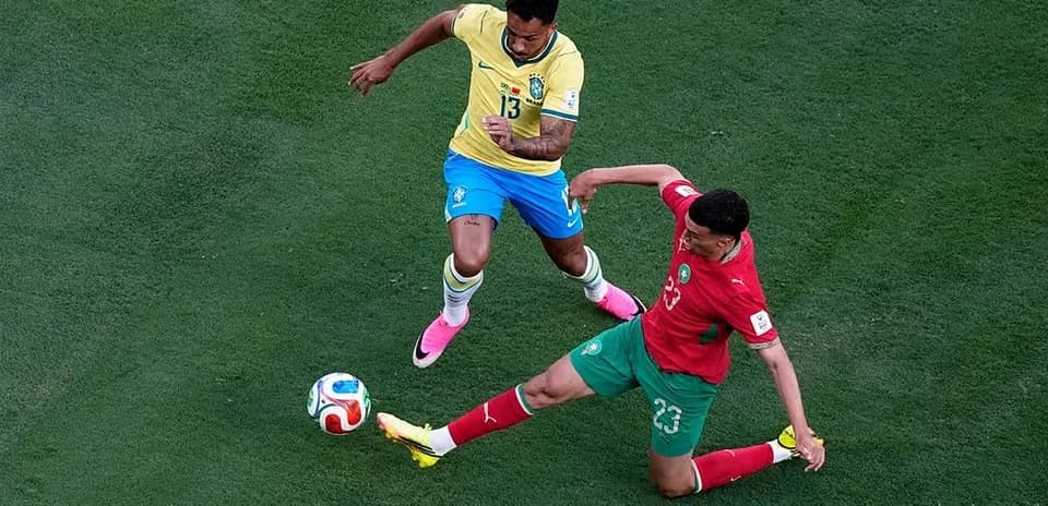 Brazil player challenging Morocco player for the ball